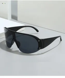 Detail view of black shield sunglasses showing metal rivets and smooth texture material