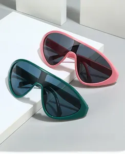 Detail view of oversized shield sunglasses with thick frames in pink and dark green colors