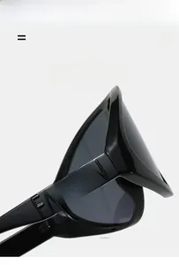 Detail of wide black oversized sunglasses temple featuring 3D embossed FASHION lettering