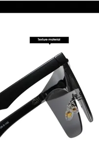 Detailed macro view of black oversized shield sunglasses with metal hinge and nose pads