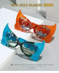 Detail of bat wing shaped sunglasses in vibrant orange and blue with tortoiseshell accents