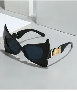 Detail of bat-wing cat-eye sunglasses with gold metal chain temple ornaments