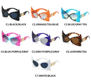 Detail of bat-wing shaped sunglasses featuring unique cutout gold metal temple accents