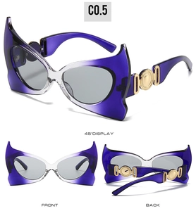 Detail view of purple bat-wing sunglasses with gold metal hinges and gradient frame