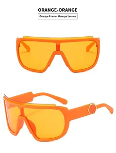 Detail of orange cycling sunglasses featuring integrated frame and gold hexagonal metal accents