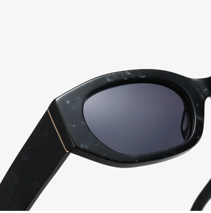 Detail of black marble texture frame with golden metal accents on fashion sunglasses