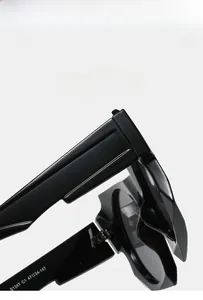 Close-up of black acetate sunglasses showing temple hinge and S1247 C1 model engraving
