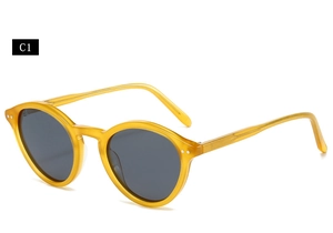 Detail of amber tortoiseshell oval sunglasses frame with silver rivet hinges and dark lenses