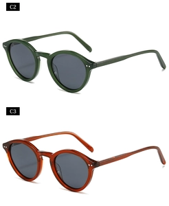 Detail of retro oval thick-frame sunglasses in transparent green and amber colors