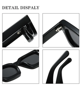 Detail view of bold black square sunglasses featuring thick frames and reinforced metal hinges