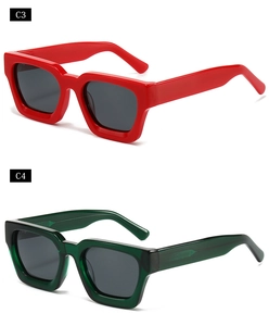 Detail view of bold chunky rectangle sunglasses in glossy red and translucent green frames
