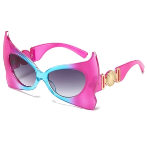 Fashionable bat-shaped sunglasses with pink and blue gradient frames and gold accents