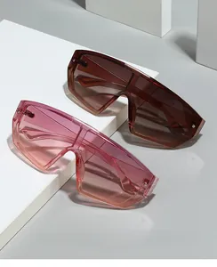 Détails de lunettes de soleil masque oversize marron et rose sur des supports géométriques
