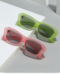 Détail de lunettes de soleil carrées vintage vert néon et rose sur socle géométrique