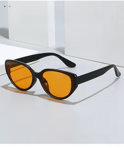 Close-up of cat-eye sunglasses with glossy black frames and vibrant orange lenses
