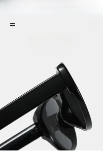 Close-up of black glossy cat-eye sunglasses showing temple hinges and frame texture