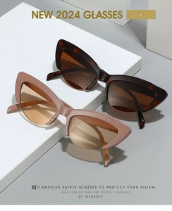 Detail of tortoise and pink cat-eye computer safety glasses on white geometric blocks