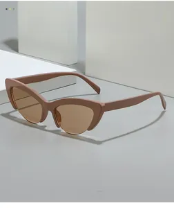 Detail of matte cat eye sunglasses in nude pink with brown lenses on geometric stand