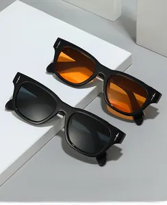 Détail d'une lunette de soleil carrée noire avec une décoration de dague en métal argenté