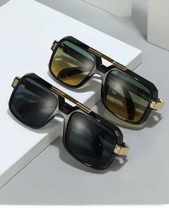 Detail view of square retro sunglasses with gold metal bridge and matte black frames