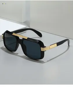 Detail of square black sunglasses featuring bold gold metal accents on high-gloss frames