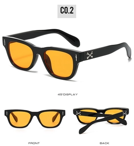 Détails macro de lunettes punk carrées avec verres orange et ornements d'épées argentées