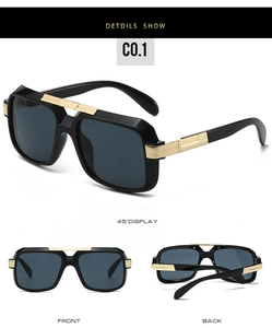 Macro detail of glossy black square sunglasses frame with golden metal hinges and gray lenses