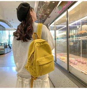 Outdoor shot showing back view of yellow corduroy backpack with texture detail