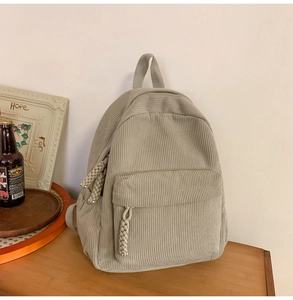Detail of soft corduroy fabric and zipper pocket on a beige vintage backpack