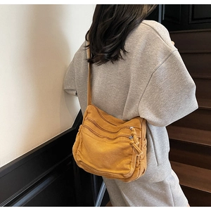 Detail of ginger corduroy tote bag featuring multi-zipper pockets and shoulder strap