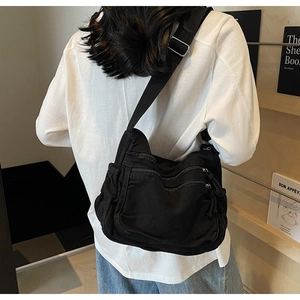 Rear view of black canvas multi-pocket tote bag showing adjustable strap and size