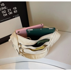 Top view of cream canvas tote bag showing spacious compartments with tablets and accessories