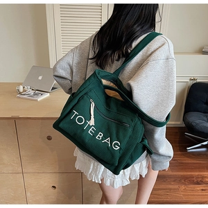 Detail der dunkelgrünen Cord-Einkaufstasche mit TOTEBAG-Stickerei und Reißverschlusstasche