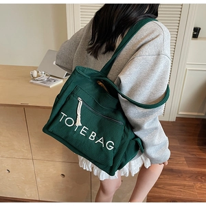 Detailansicht einer dunkelgrünen Cord-Einkaufstasche mit weißer TOTE BAG Bestickung