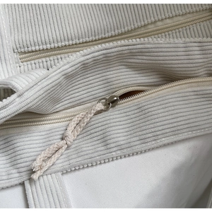 Nahaufnahme der beigen Cord-Einkaufstasche mit Rippstruktur und Seil-Reißverschluss-Detail