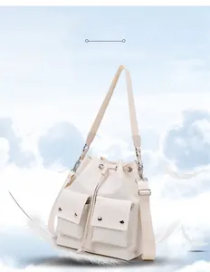 Close-up of lightweight cream nylon drawstring shoulder bag with metal buckle pockets