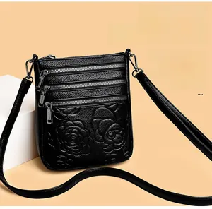 Close-up of black embossed floral pattern on leather bucket bag with triple zipper detail