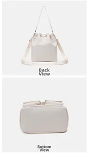 Detail view of the back and rectangular bottom of this white nylon drawstring bucket bag