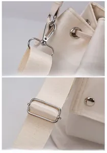 Detail of adjustable strap with metal hooks and drawstring closure on cream nylon bag