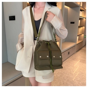 Detail of army green nylon bucket bag with drawstring closure and front double pockets