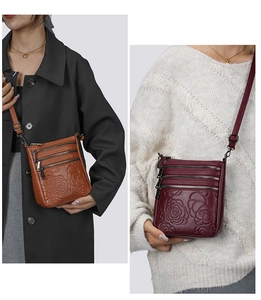 Close-up of multi-zipper leather crossbody bag with rose embossed pattern details