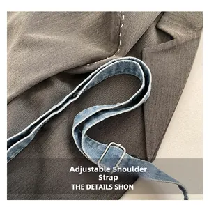 Detail of adjustable denim shoulder strap with silver metal buckle on a casual bag