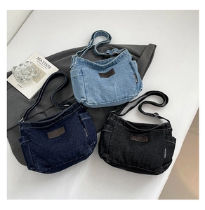 Detail view of denim crossbody bags in light blue, dark blue and black colors