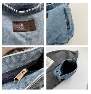 Detail view of light blue denim tote with leather brand patch and metal zipper closure