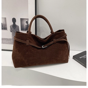 Detail of dark brown suede tote bag with silver buckle and belt decoration