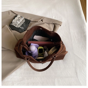 Macro view of large brown suede tote bag showing spacious interior with daily essentials