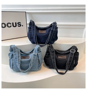 Close-up of denim shoulder bags in blue and black with brown leather patches and straps