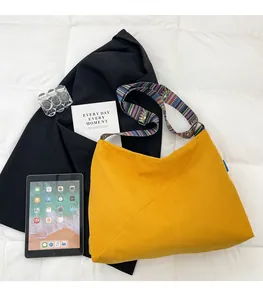Detailed view of yellow corduroy tote bag featuring a colorful ethnic patterned strap