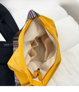 Detail view of yellow corduroy tote bag showing interior lining and zipper pocket