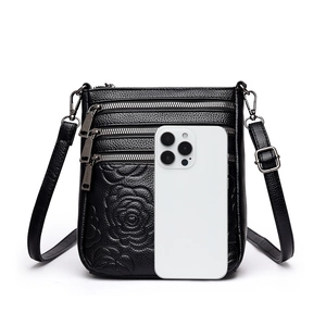 Black leather bucket bag with rose embossing and triple zipper front shown with phone